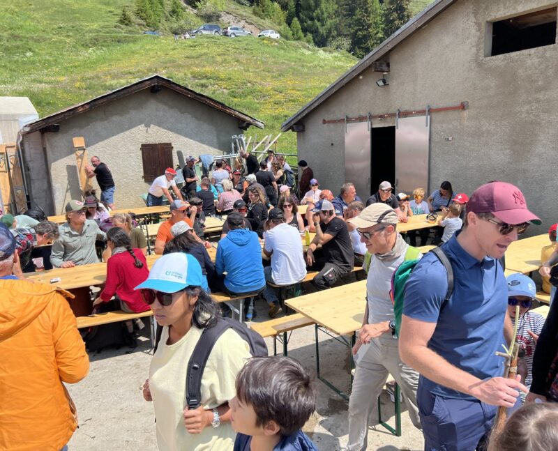 Hôtes attablés devant l'entrée de l'étable